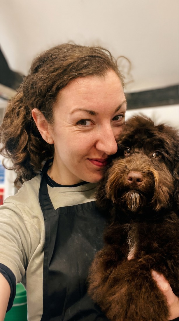 Lauren, Upper Hound’s salon manager, with a chocolate doodle cheek to cheek
